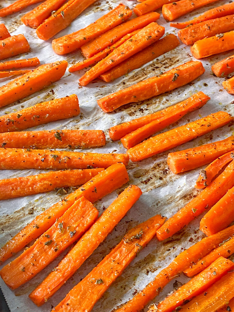 freshly roasted carrot sticks on a baking sheet