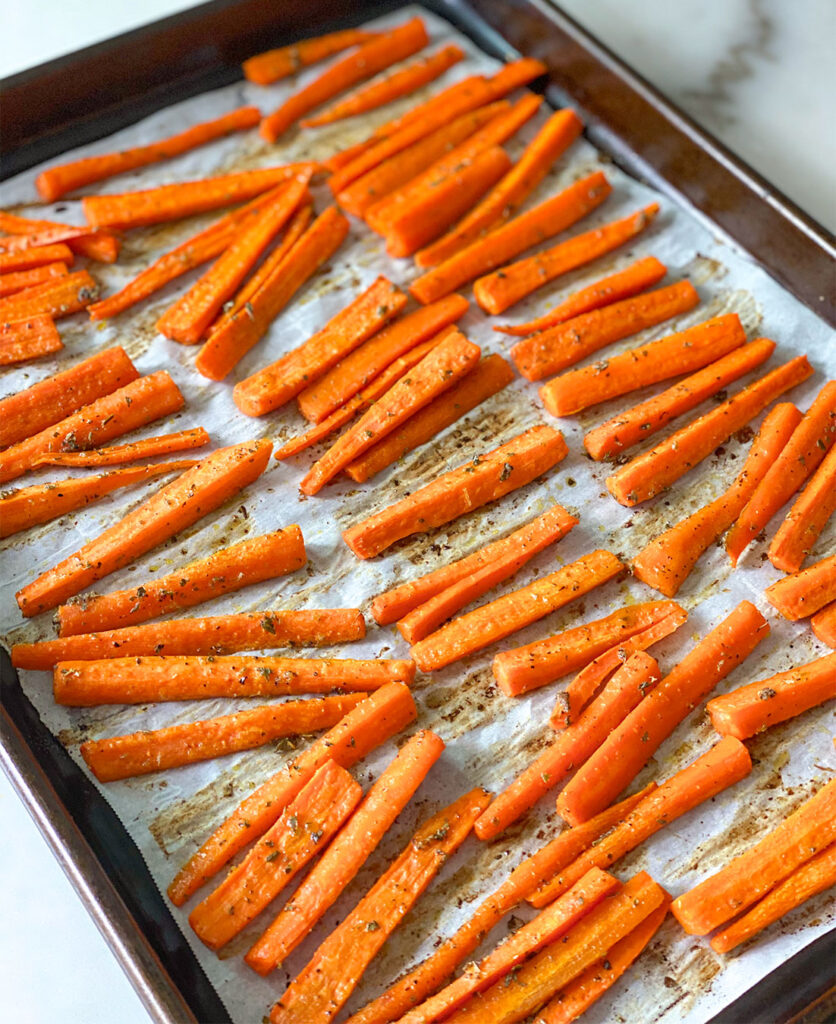 freshly roasted carrot sticks on a baking sheet