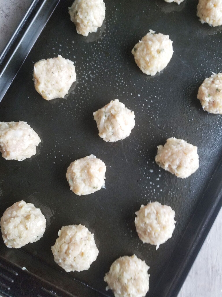 chicken meatballs on a baking sheet ready to go in the oven