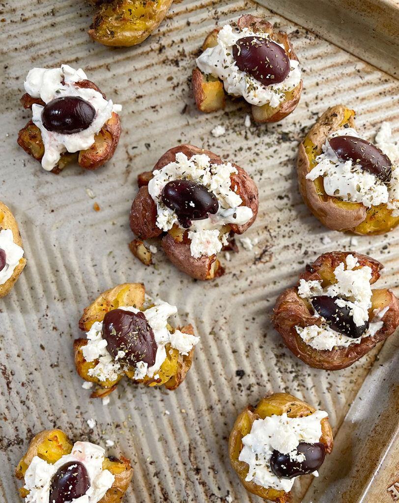 mediterranean inspired smashed potatoes on a baking sheet