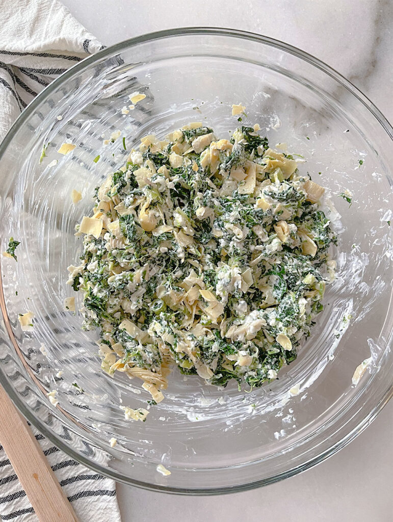 spinach artichoke feta dip ingredients mixed in a bowl