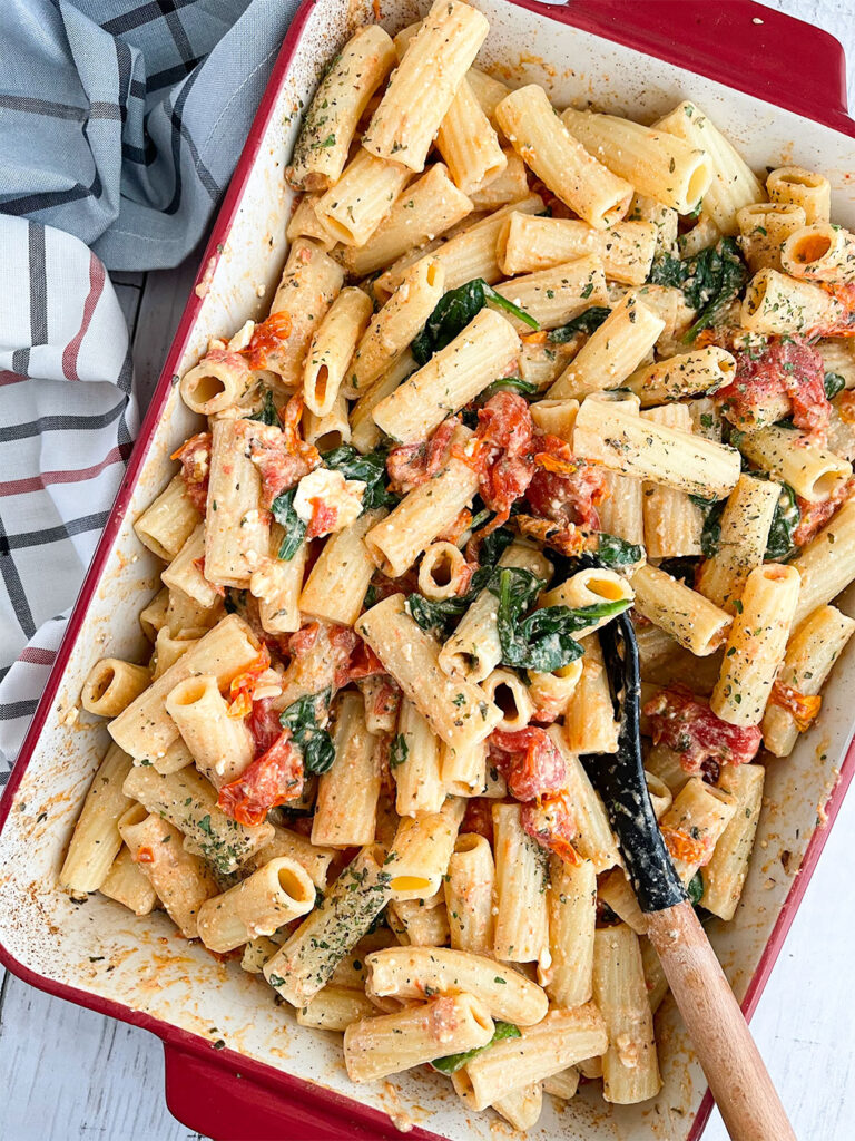 Pasta, tomatoes, spinach and feta cheese in a baking dish