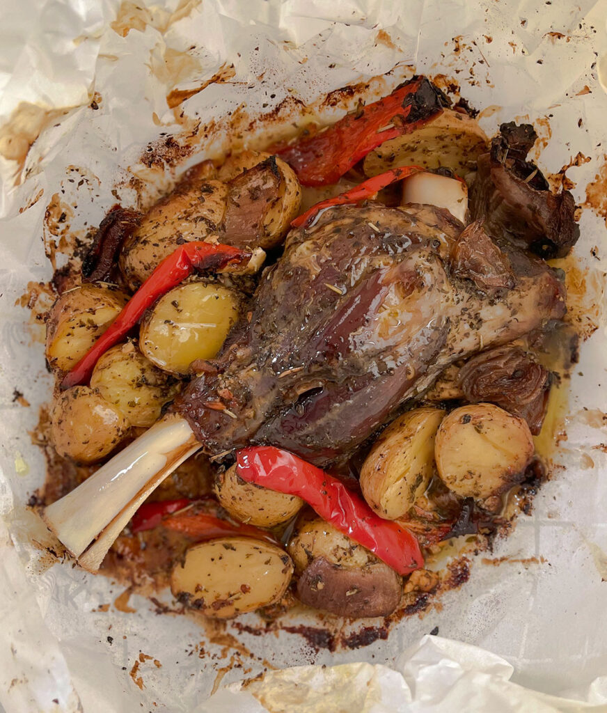 lamb shank, potatoes, peppers and onions roasted in a parchment paper pouch