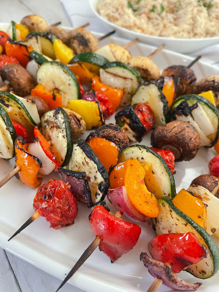 marinated grilled vegetables on wooden skewers with rice pilaf