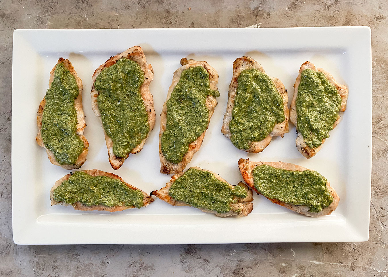 Grilled chicken breasts topped with homemade pesto sauce