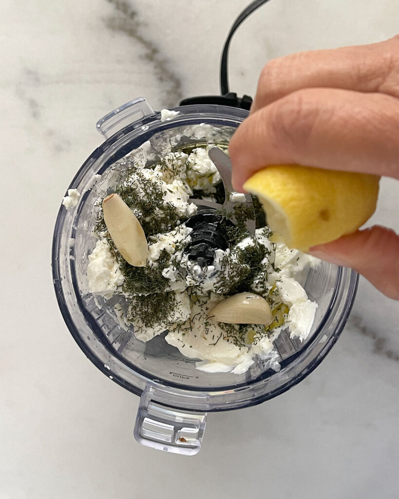 A series of pictures showing the process of making the creamy feta dressing. Add the yogurt, feta, olive oil, garlic, dill and fresh lemon juice.