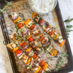 A tempting tray of sizzling Grilled Halloumi Skewers, featuring perfectly grilled Halloumi cheese, colorful peppers, zucchini ribbons, and cherry tomatoes, ready to be enjoyed with friends and family