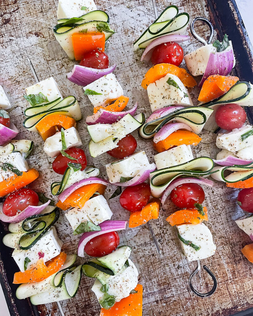 Fresh ingredients for Grilled Halloumi Skewers, ready to be transformed into a flavorful masterpiece.
Marinated ingredients in a bowl, prepping for the skewer assembly.
Skewers loaded with marinated goodness, primed for the sizzling grill.