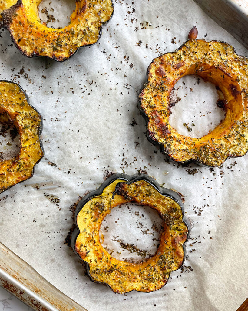 Baked acorn squash on a sheet pan.