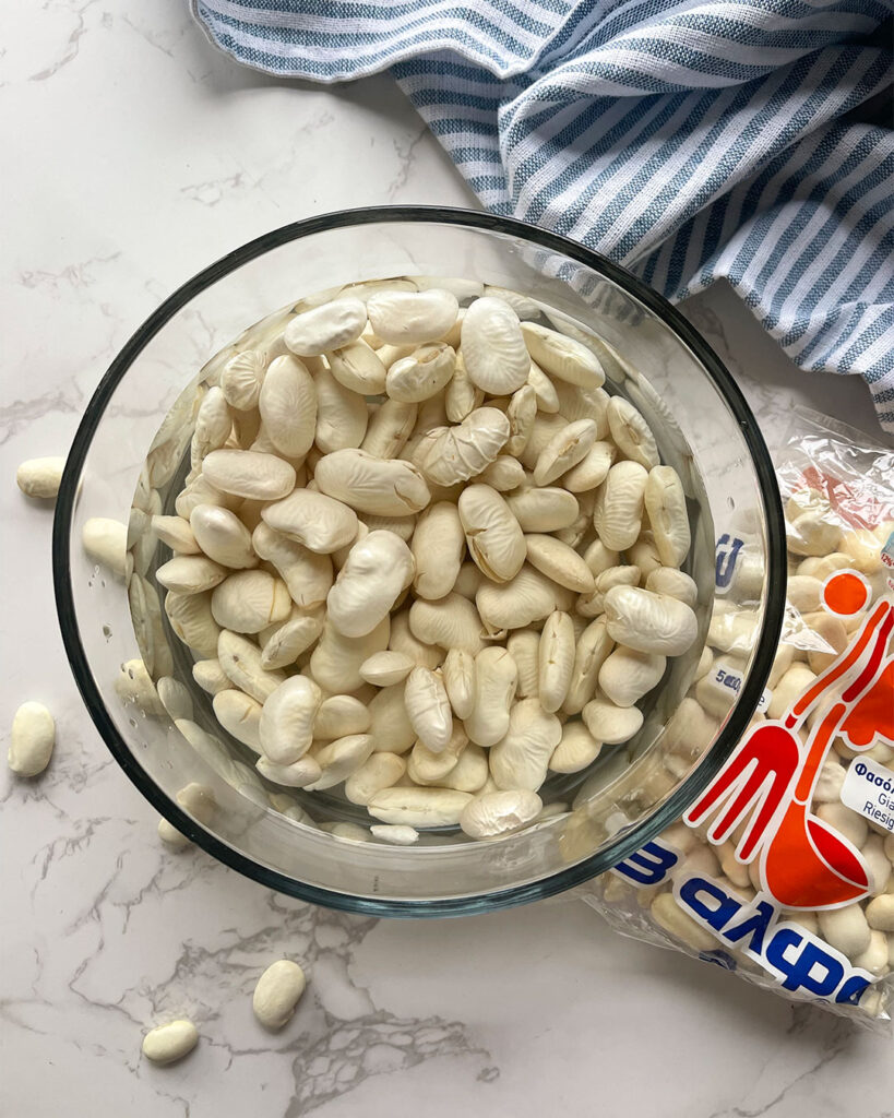 Gigantes beans soaking in a bowl of water