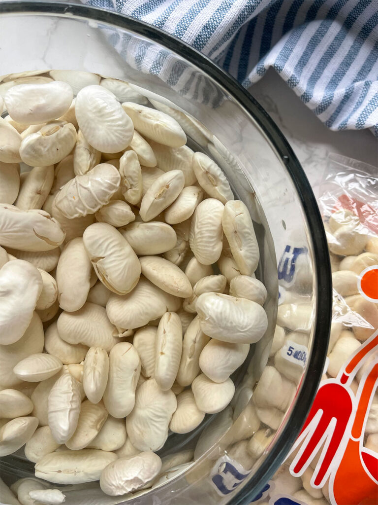 Gigantes beans soaking in a bowl of water